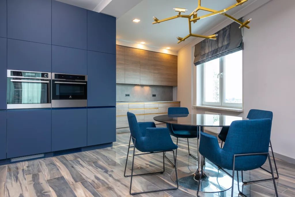 Modern kitchen interior with chandelier and grey window shades in house. Photo by Max Rahubovskiy on Pexels