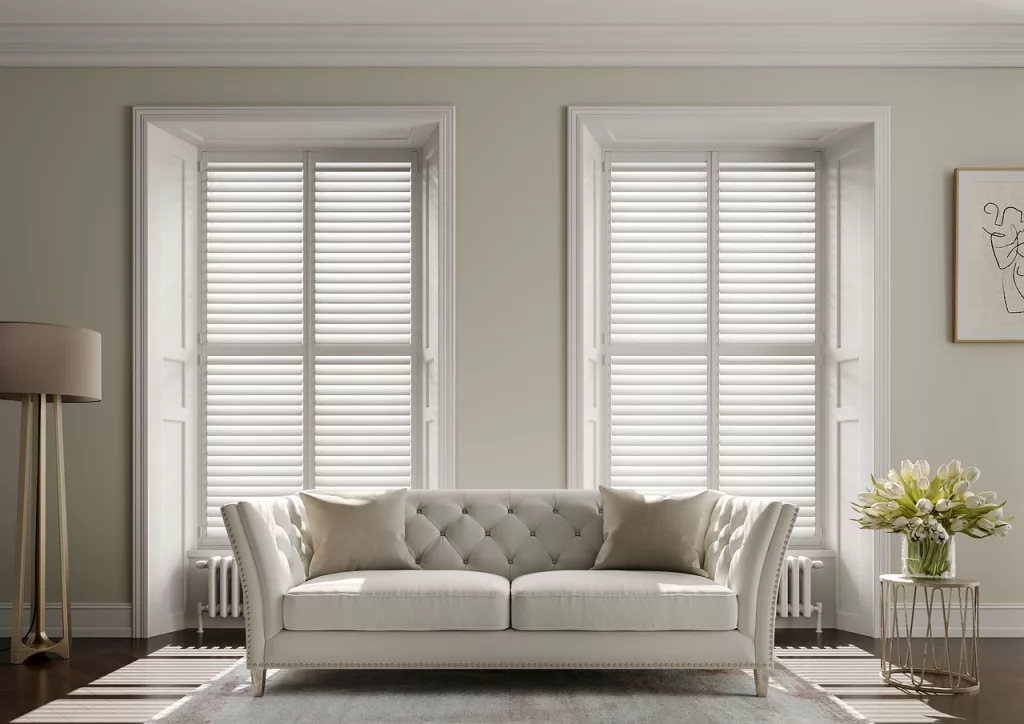 Modern home interior with white sofa and white window shutters in the background