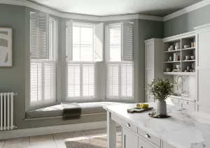 Modern kitchen interior with white window shutters on the left side